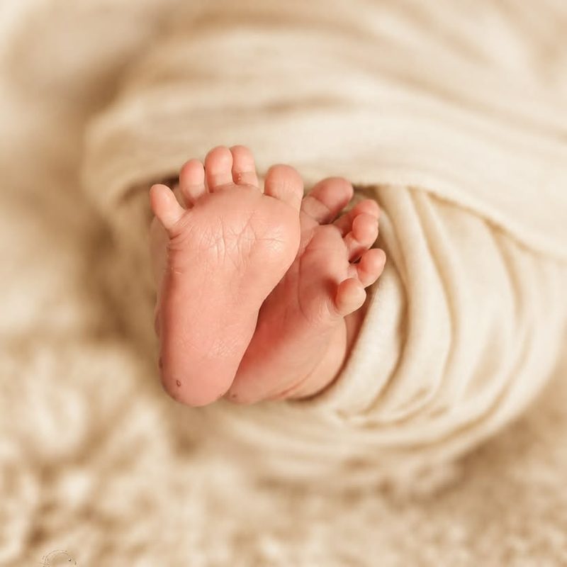 Newborn feet wrapped in a soft blanket
