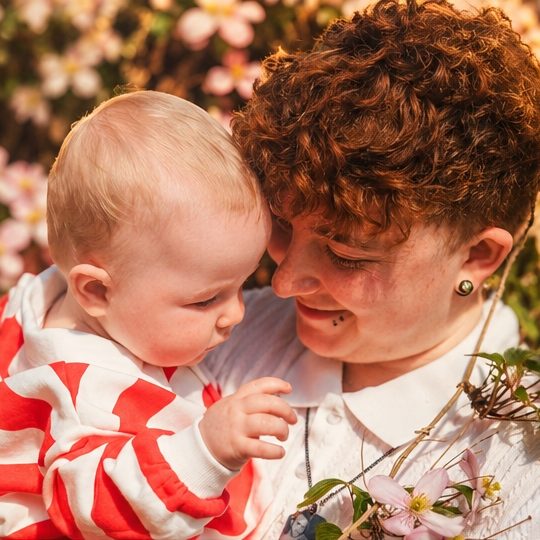 Parent and baby nose to nose among flowers