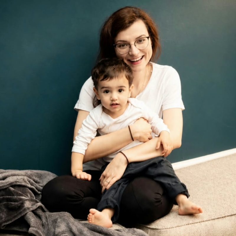 Mum and toddler at home against a deep green wall